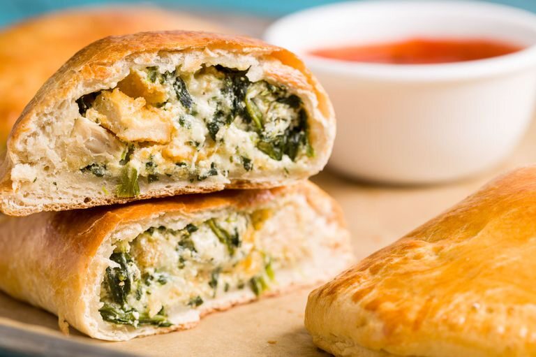 Big Ben spinach and ricotta calzone cut open with marinara dipping sauce