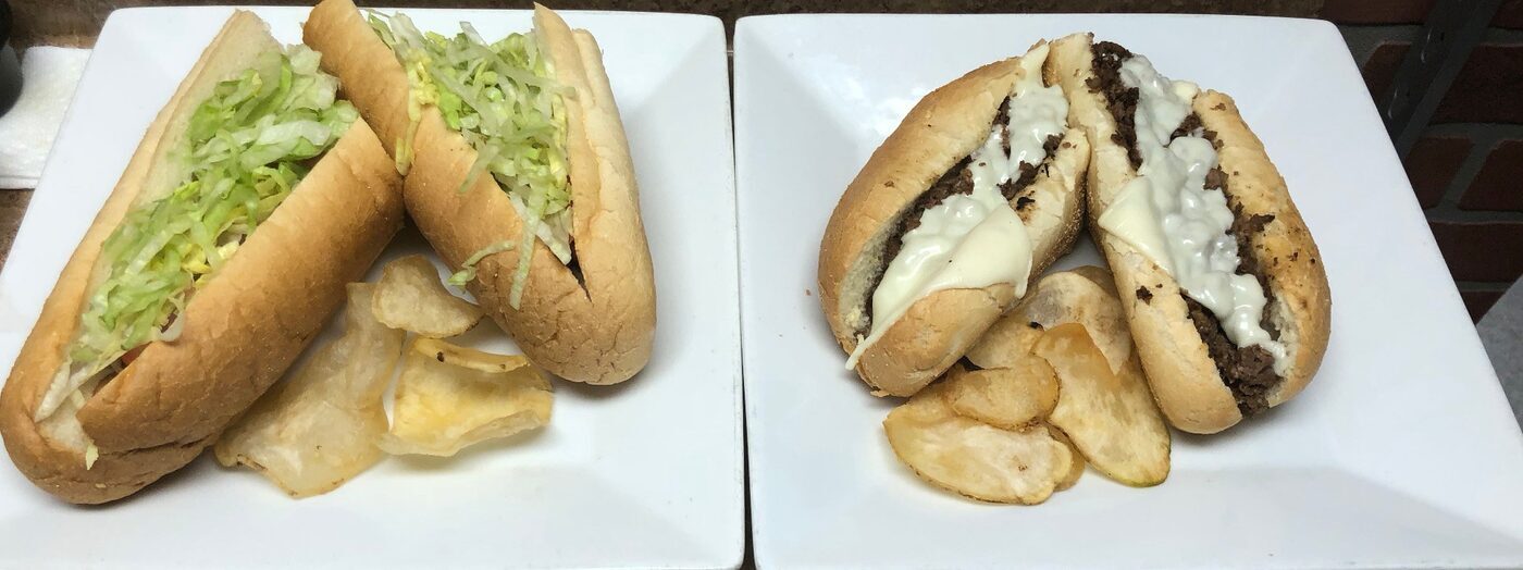 Big Ben hot subs — lettuce sub and Philly cheesesteak on white plates